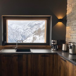 Cuisine bois sombre avec grande fenêtre donnant sur les montagnes