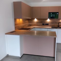 Petite cuisine en U rose poudré et blanche avec plan de travail bois